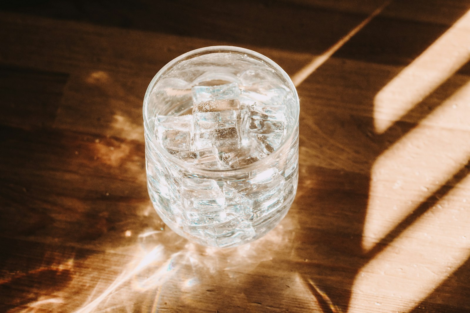 A glass of water with condensation on a wooden table